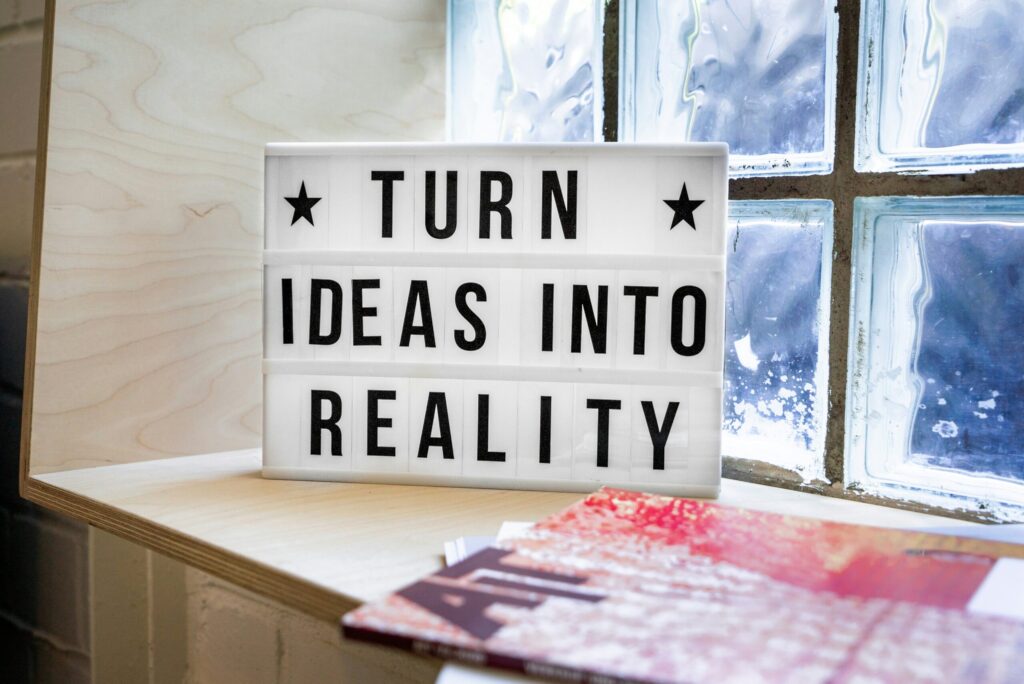 Letrero luminoso con la frase turn ideas into reality, que representa el paso de la estrategia digital a la ejecución en un negocio pequeño